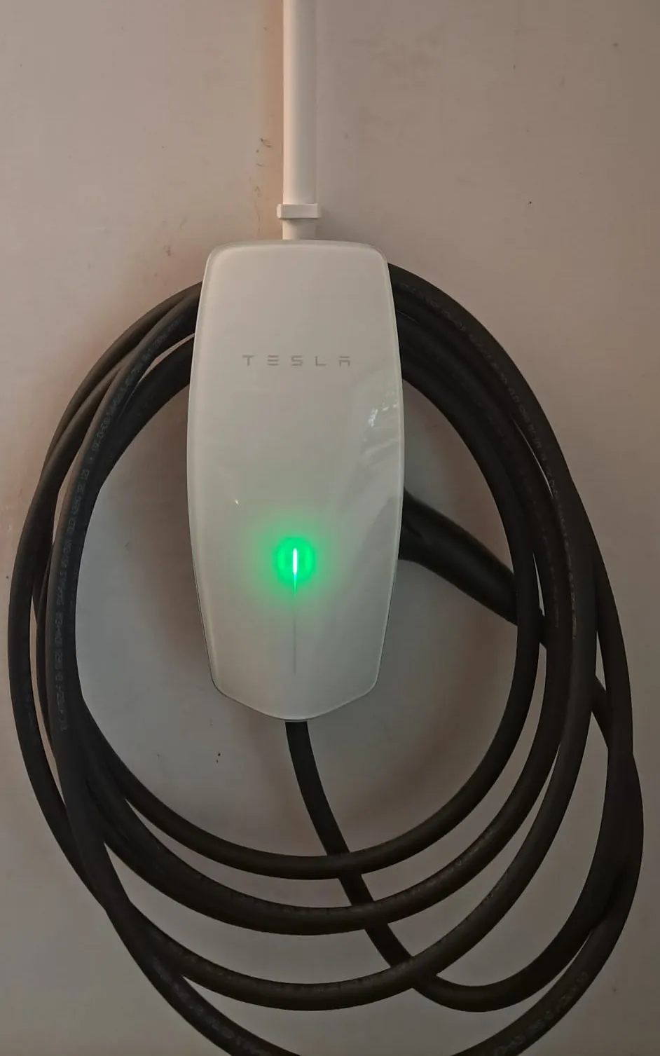 Ładowarka Tesla Wall Connector 11 kW z zawieszonym kablem na ścianie domu jednorodzinnego, ograniczona do 10 A na fazę, Magdalenka pod Warszawą