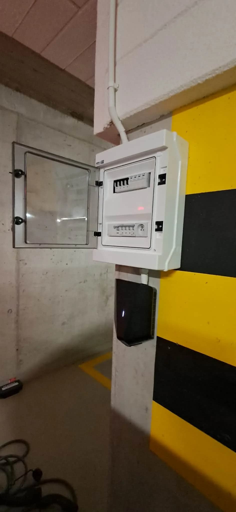 Tablica rozdzielcza z zabezpieczeniami i ładowarka Easee UP 11 kW przy miejscu postojowym w garażu podziemnym, Wilanów Warszawa